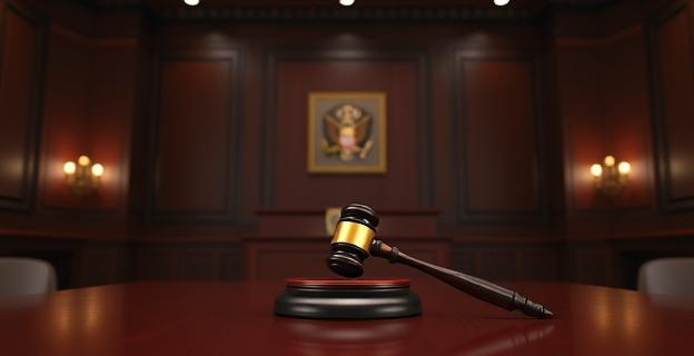 Una imagen de una sala de justicia con un estrado vacío y un martillo de juez sobre la mesa, simbolizando la espera de la nueva fiscal general.
