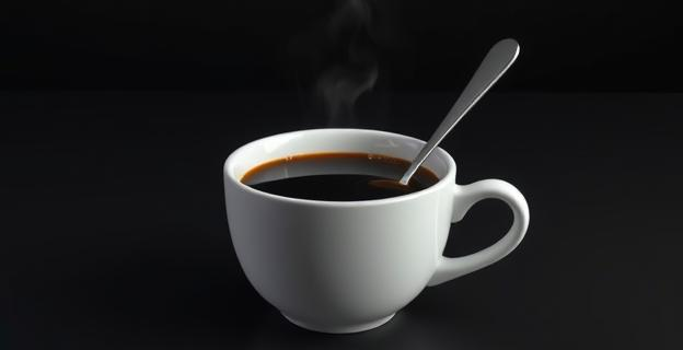 Una taza de café con un fondo oscuro y una cuchara, representando la diferencia entre un café de alta calidad y uno de baja calidad