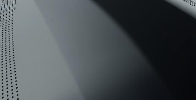 Imagen de un cristal de coche con puntos negros en degradado en sus bordes, mostrando claramente la transición entre la zona negra y la transparente. El cristal está curvado y muestra una textura ligeramente rugosa en los bordes.