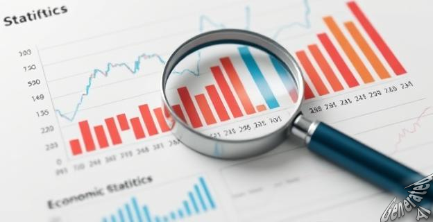 Una imagen de un gráfico de estadísticas económicas con una lupa y un bolígrafo al lado, simbolizando el análisis y la verificación de datos.